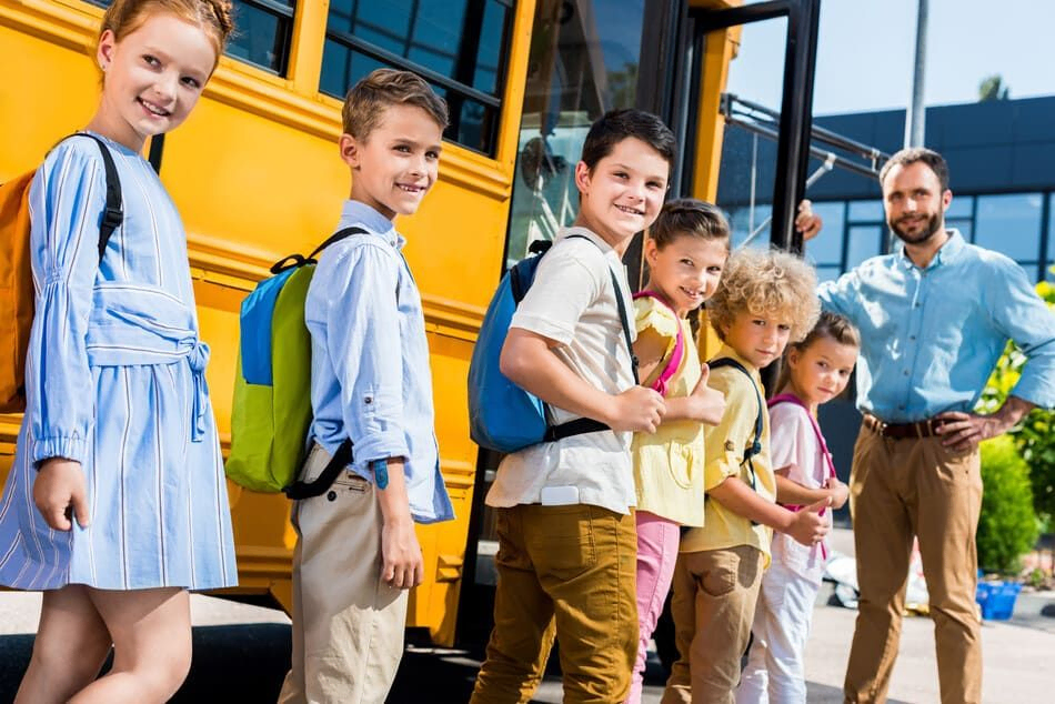niños en fila para entrar al autobús escolar