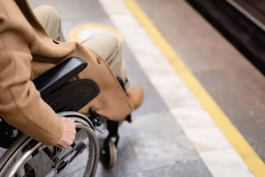 persona en silla de ruedas en parada de autobús